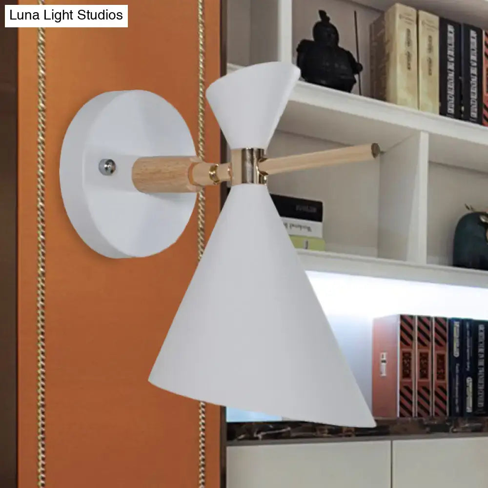Modern white conical wall sconce with wooden arm and brass accents featuring an angle shade for bedroom lighting