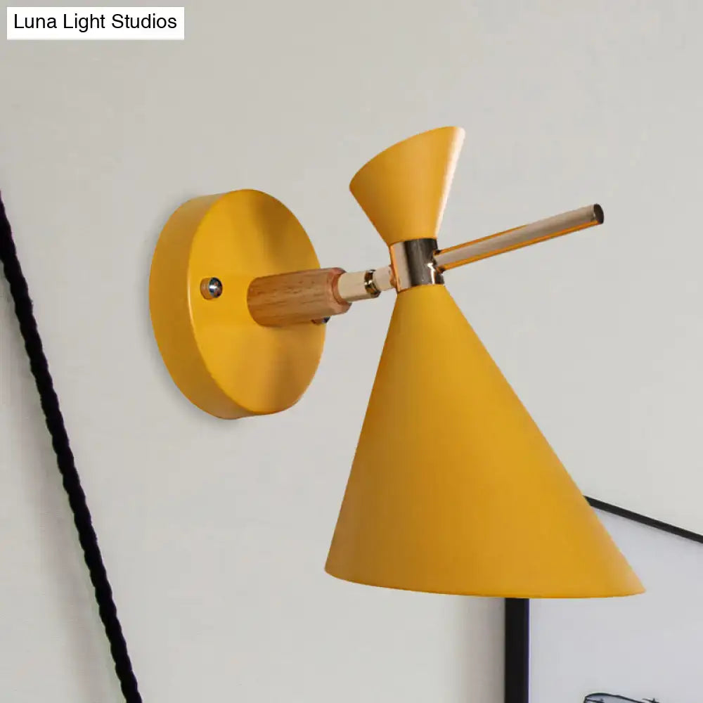 Bright yellow wall sconce with conical angle shade, wooden arm, and metallic accents for modern bedroom lighting