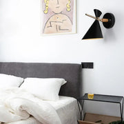 Modern black angle shade wall sconce with wooden arm and brass hardware for bedroom lighting