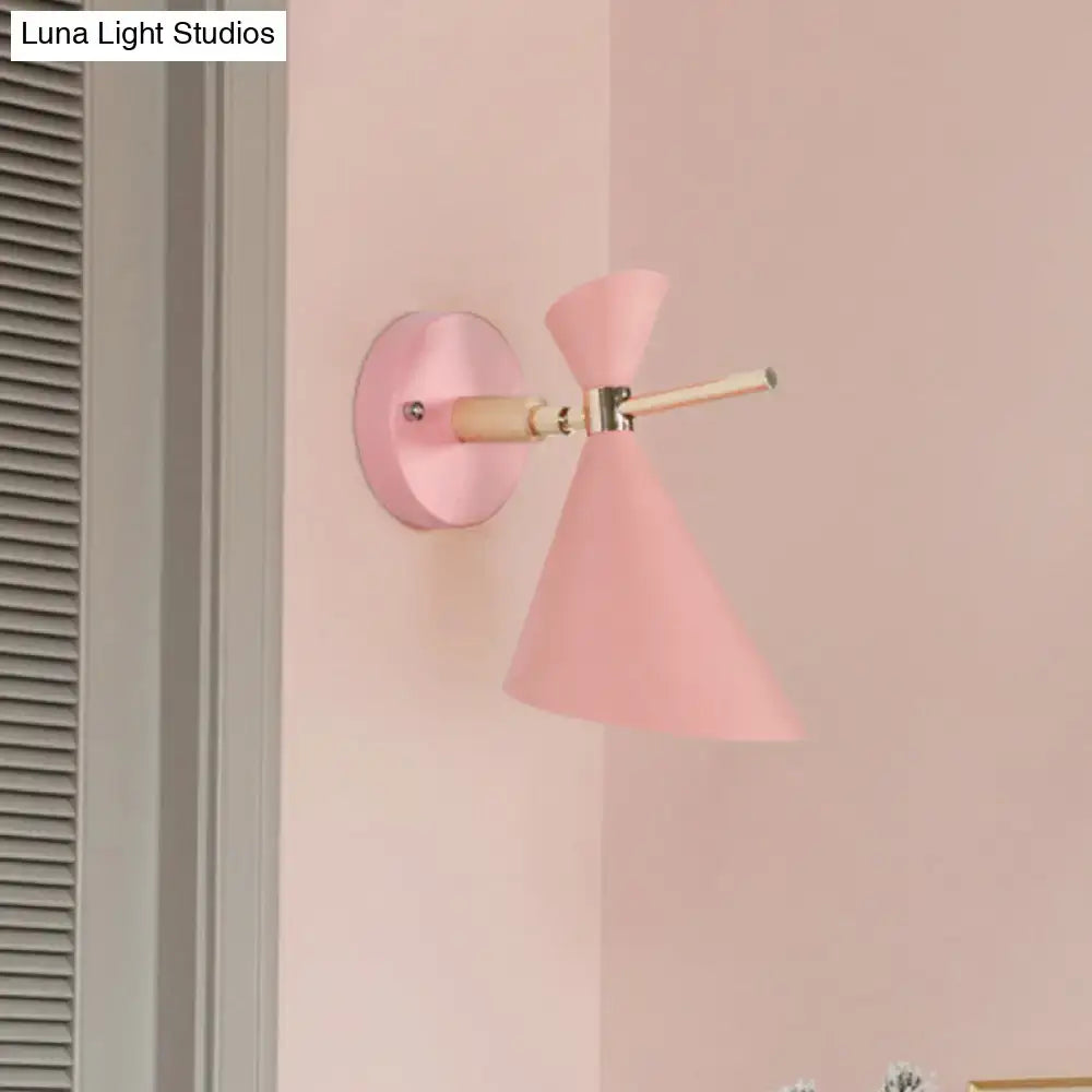 Modern black angle shade wall sconce with wood arm and pink conical matte wall sconce with brass hardware for bedroom lighting