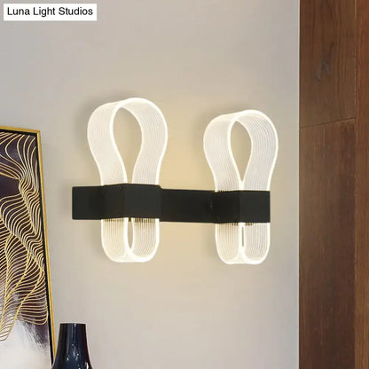 Modern black arc ring sconce wall lamp with sleek ribbon-like illuminated led arms for contemporary bedroom lighting