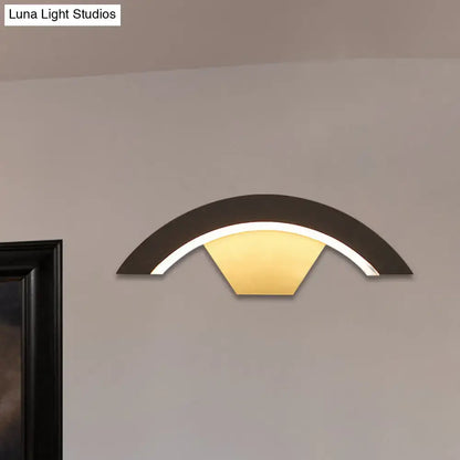Modern black arc wall sconce with warm yellow integrated led light designed for bedroom wall sconce lighting