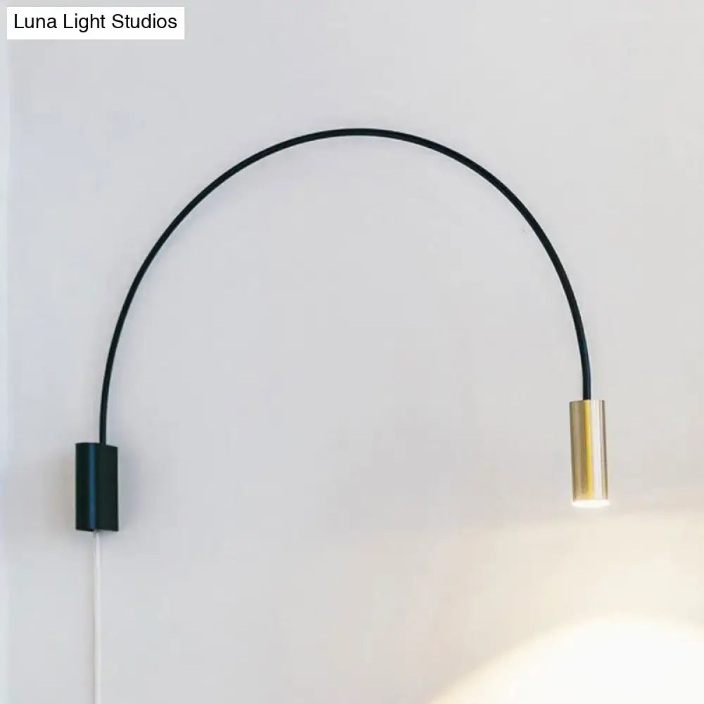 A sleek black and brass arched led wall mount light with minimalist design for modern living room use