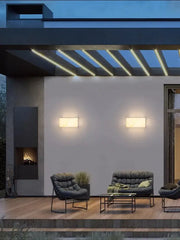 Modern black tufted outdoor sofa with sleek metal frame and green pillows complementing decorbites art deco marble wall light