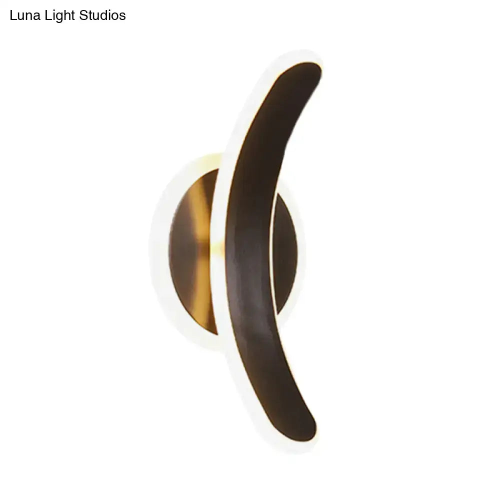 Modern wall mounted lamp with sleek black curved arm and warm gold base providing white warm light for bedroom use