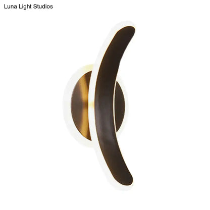 Modern wall mounted lamp with sleek black curved arm and warm gold base providing white warm light for bedroom use