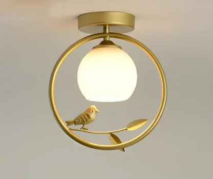 Modern black bird ceiling light fixture with a gold-toned circular frame and frosted glass globe for corridor entrance