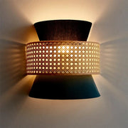 A modern black and blue dual cone wall lamp with woven cane middle section and dark tapered fabric shades