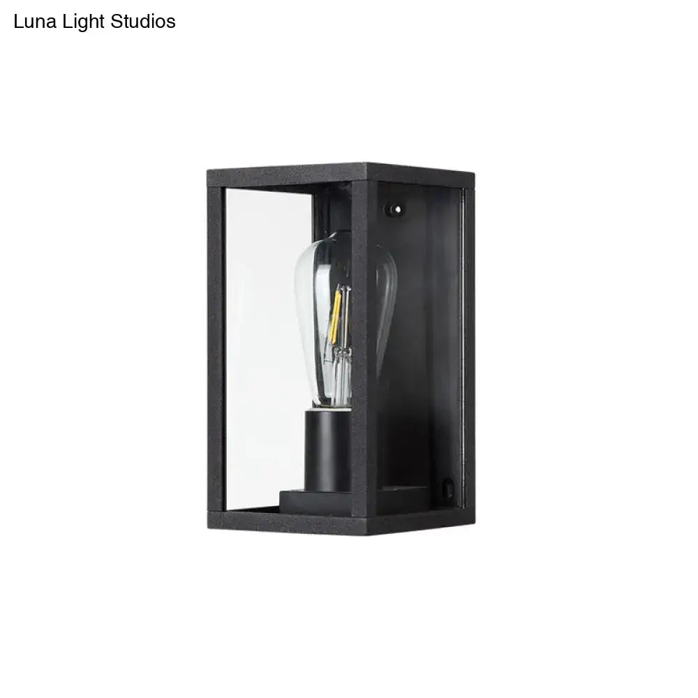 Modern black box patio wall sconce with clear glass panels and visible filament bulb for outdoor lighting
