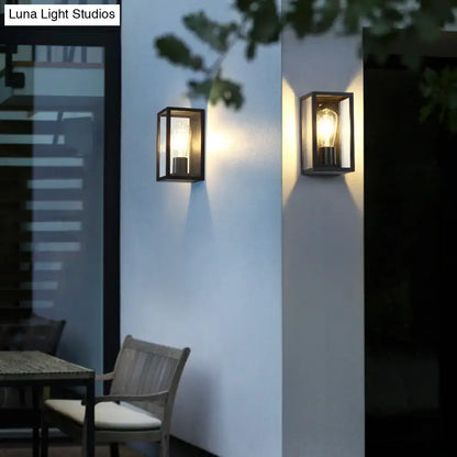 Modern black box patio wall sconce with rectangular glass panels and exposed filament bulbs for outdoor lighting