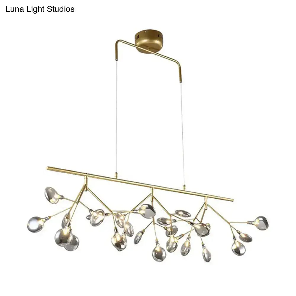 Gold-toned modern branching chandelier with clear teardrop glass pendants for dining room lighting