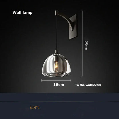 A modern black brass american wall lamp with a clear glass dome and exposed filament bulb for dining room decorbites black brass