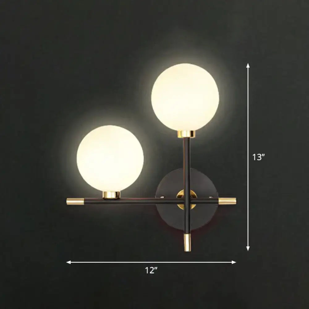 Modern black and brass wall lamp with two frosted glass ball shades and wall mounted light for bedside use