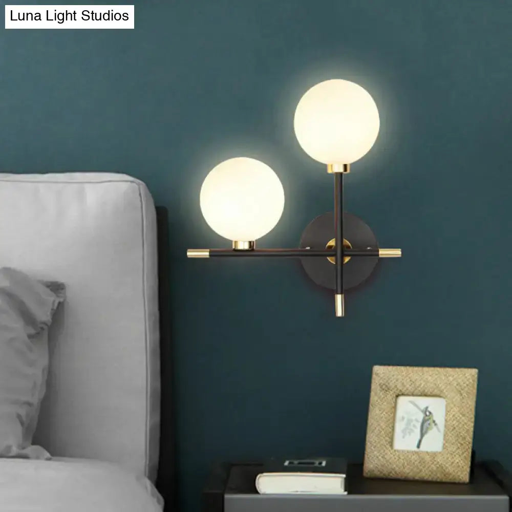 Modern black and brass wall lamp with frosted glass ball bedside sconce and sleek wall mounted light frame