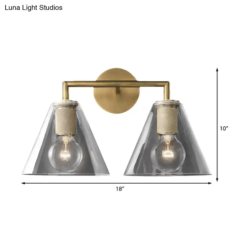 Brass-finished modern wall light with two clear glass cone shades and textured beige accents direct wired electric