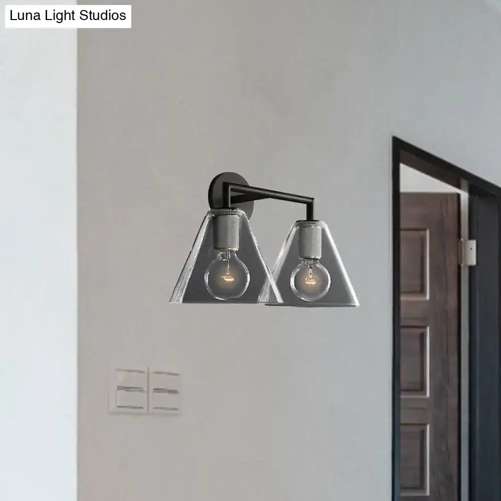 Modern black metal wall light with brass and two triangular glass shades housing exposed filament bulbs direct wired electric