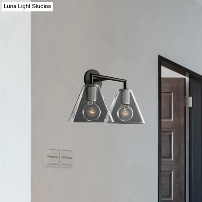 Modern black metal wall light with brass and two triangular glass shades housing exposed filament bulbs direct wired electric