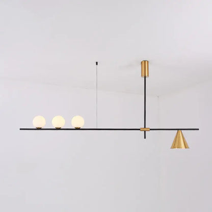 Modern black and brass linear chandelier with a sleek bar, spherical white glass bulbs, and a gold-toned conical shade