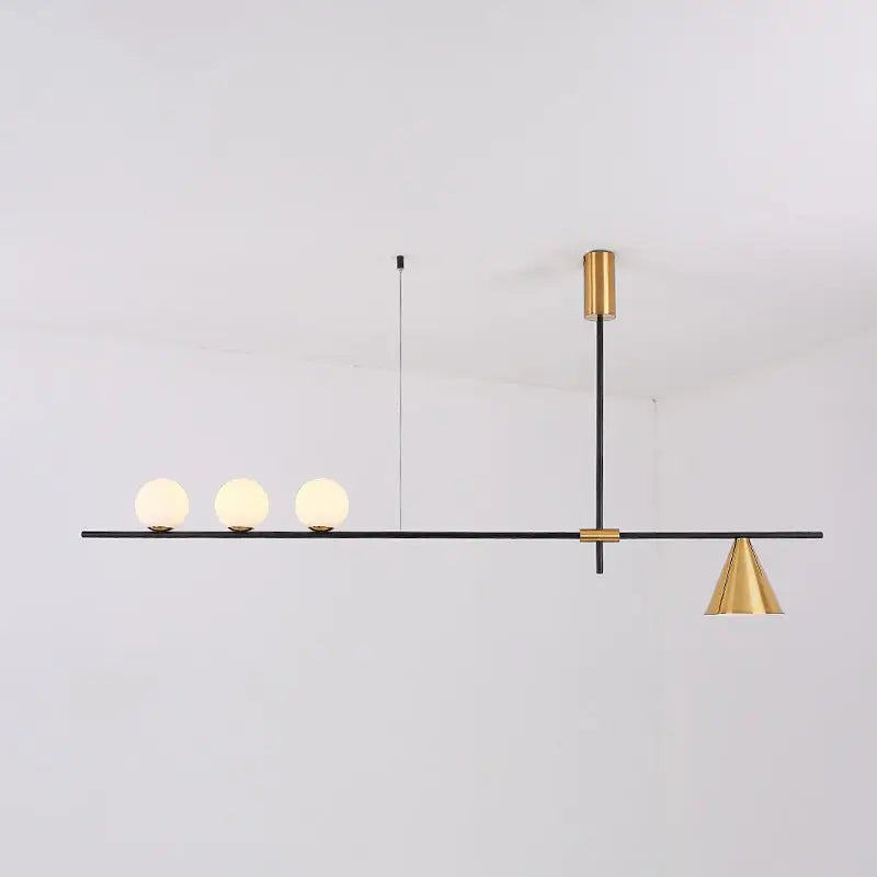 Modern black and brass linear chandelier with a sleek bar, spherical white glass bulbs, and a gold-toned conical shade