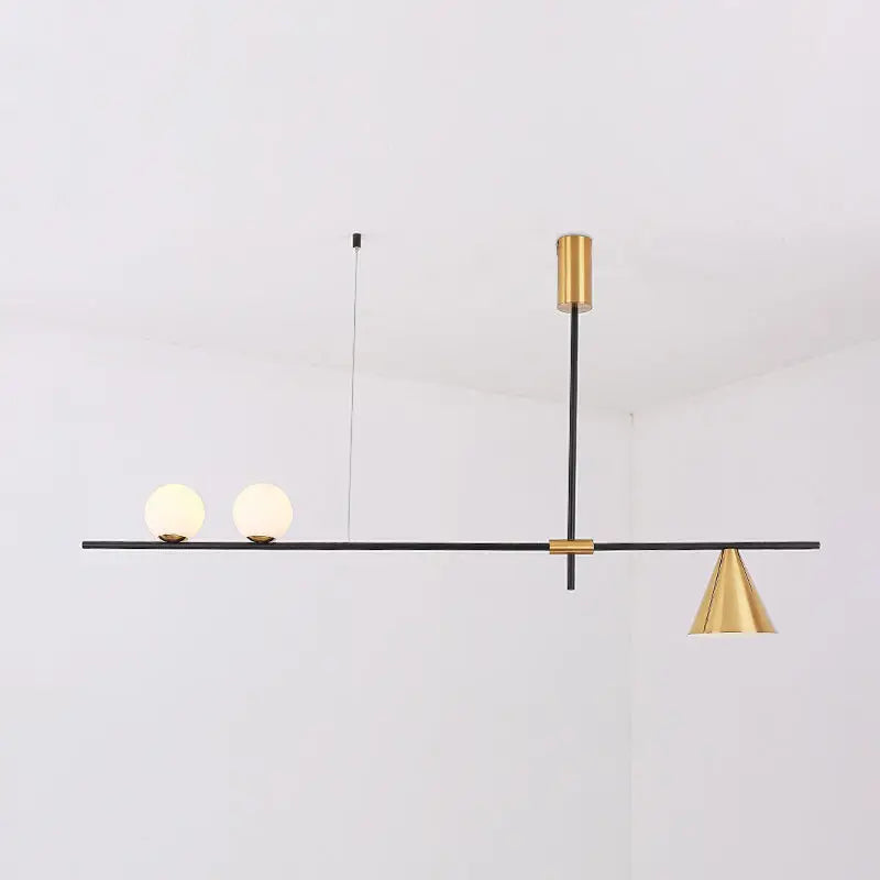 Modern black and brass linear chandelier with spherical white glass bulbs and a gold-toned conical shade for dining room
