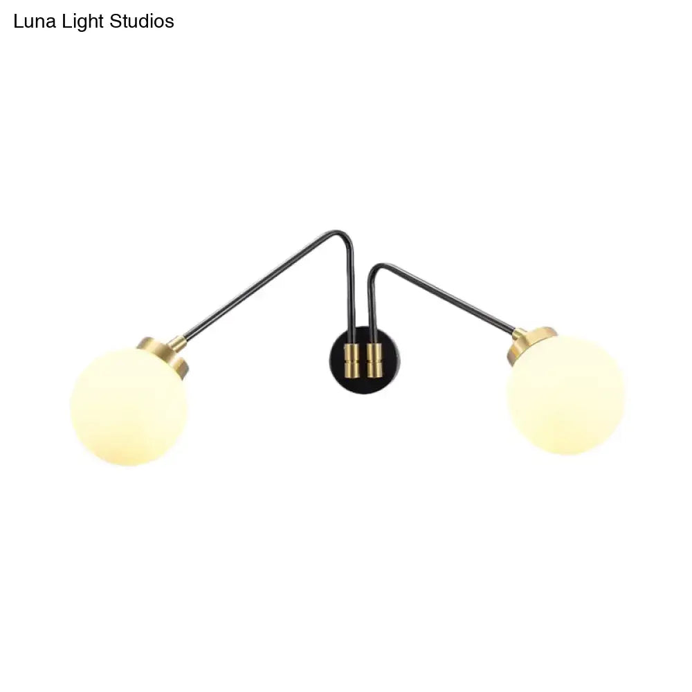 Modern black and brass double-arm wall lamp with milk glass frosted globe shades for bedroom decor