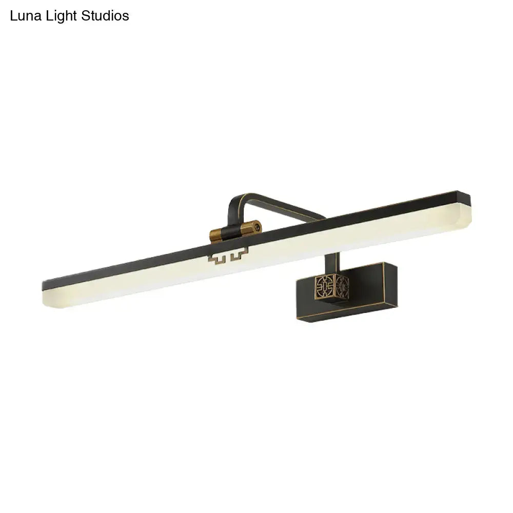 Modern black and brass wall vanity light with sleek rectangular light bar and ornate geometric bracket for metallic mirror