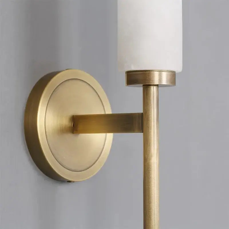 Modern black bronze brass wall lights featuring a brass-finished sconce with cylindrical white glass shade for decorbites living room decor