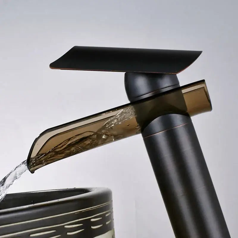 Modern black bronze glass waterfall tap with matte black finish and amber glass accent for bathroom countertop use