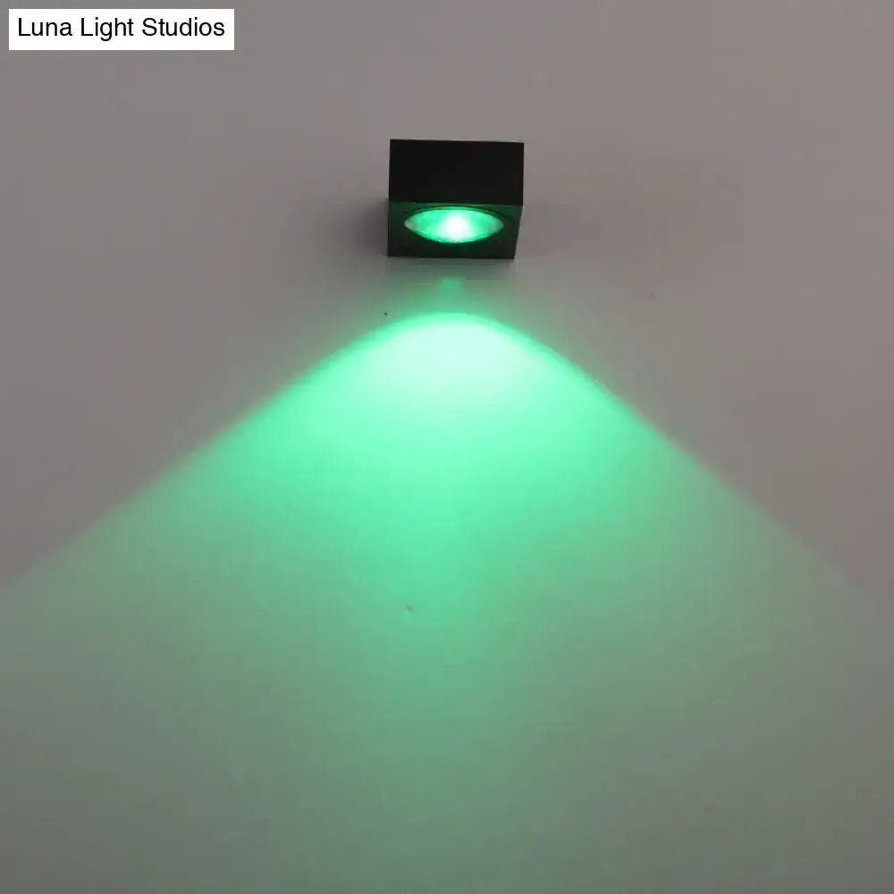 Modern black and brushed silver rgb wall lighting piece emitting a bright green beam for corridor use