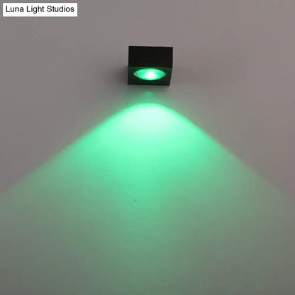 Modern black and brushed silver rgb wall lighting piece emitting a bright green beam for corridor use