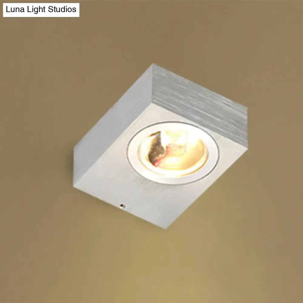Modern black and brushed silver rgb wall lighting piece with white square recessed ceiling light and warm metallic finish