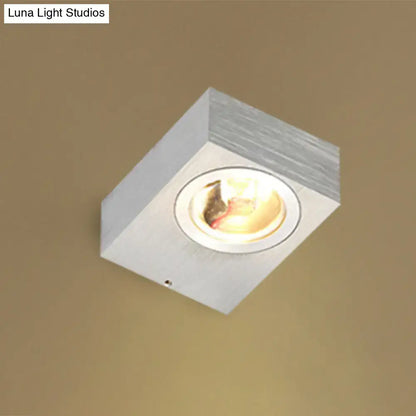 Modern black and brushed silver rgb wall lighting piece with white square recessed ceiling light and warm metallic finish