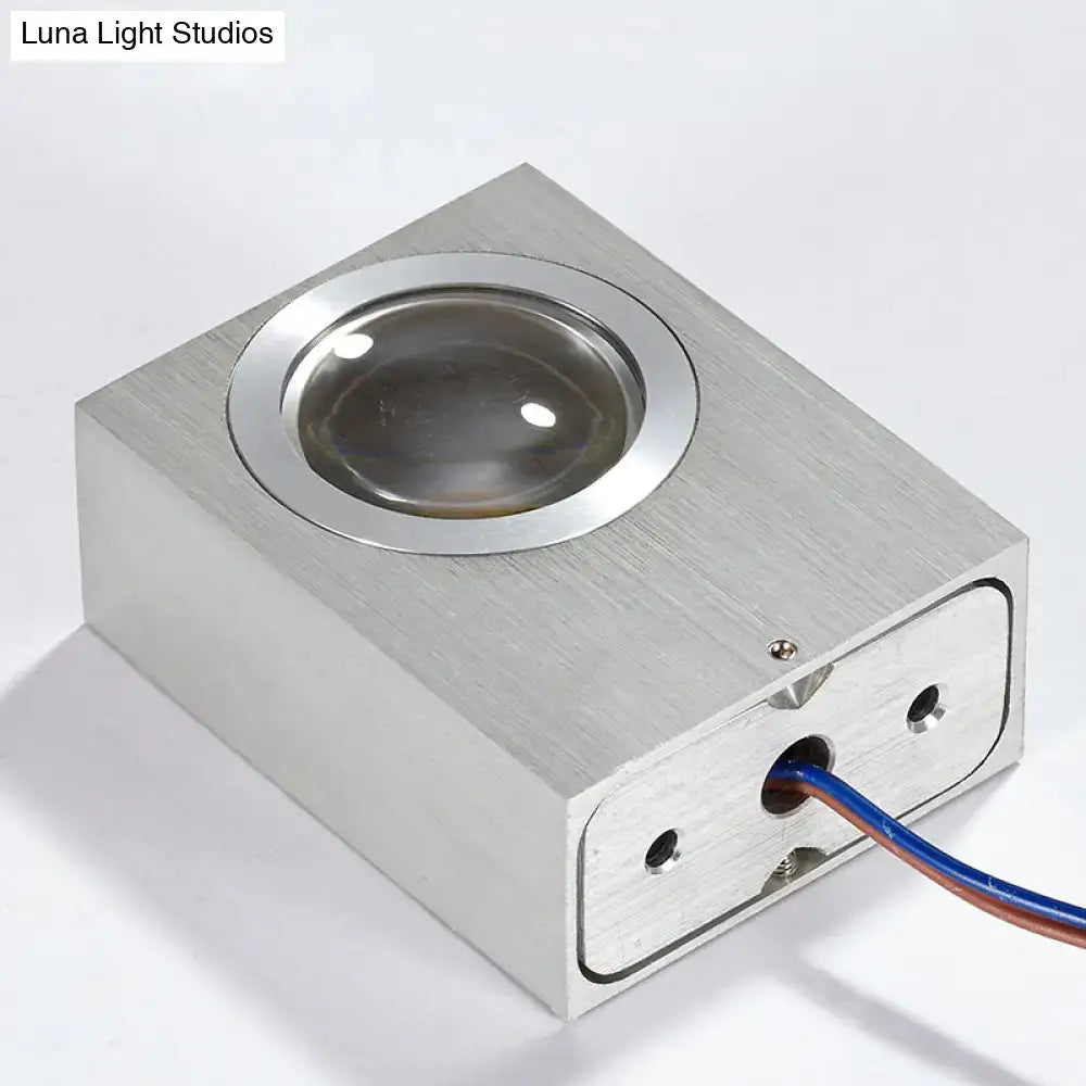 Silver rectangular rgb wall lighting piece with brushed silver finish and circular glass lens for corridor use