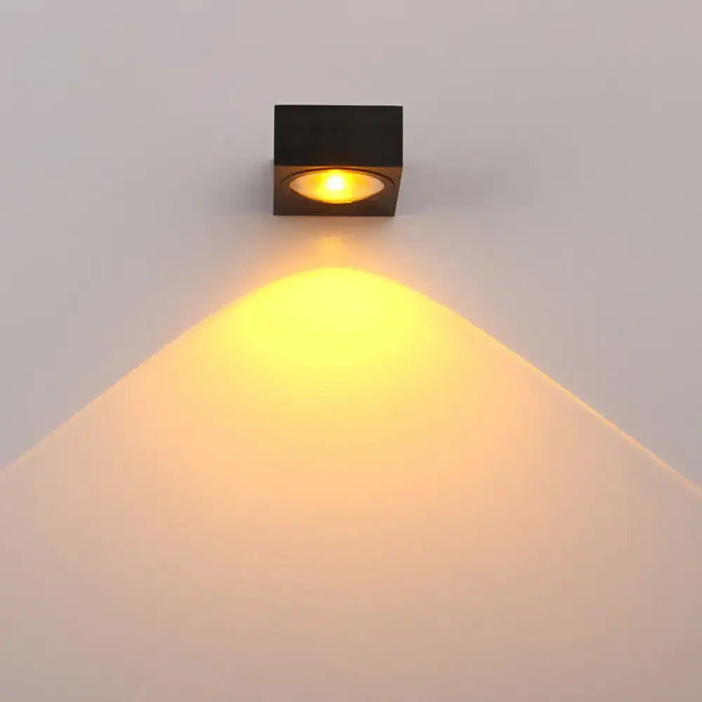 Modern black and brushed silver rgb wall lighting piece with led spotlight emitting warm yellow glow for corridors
