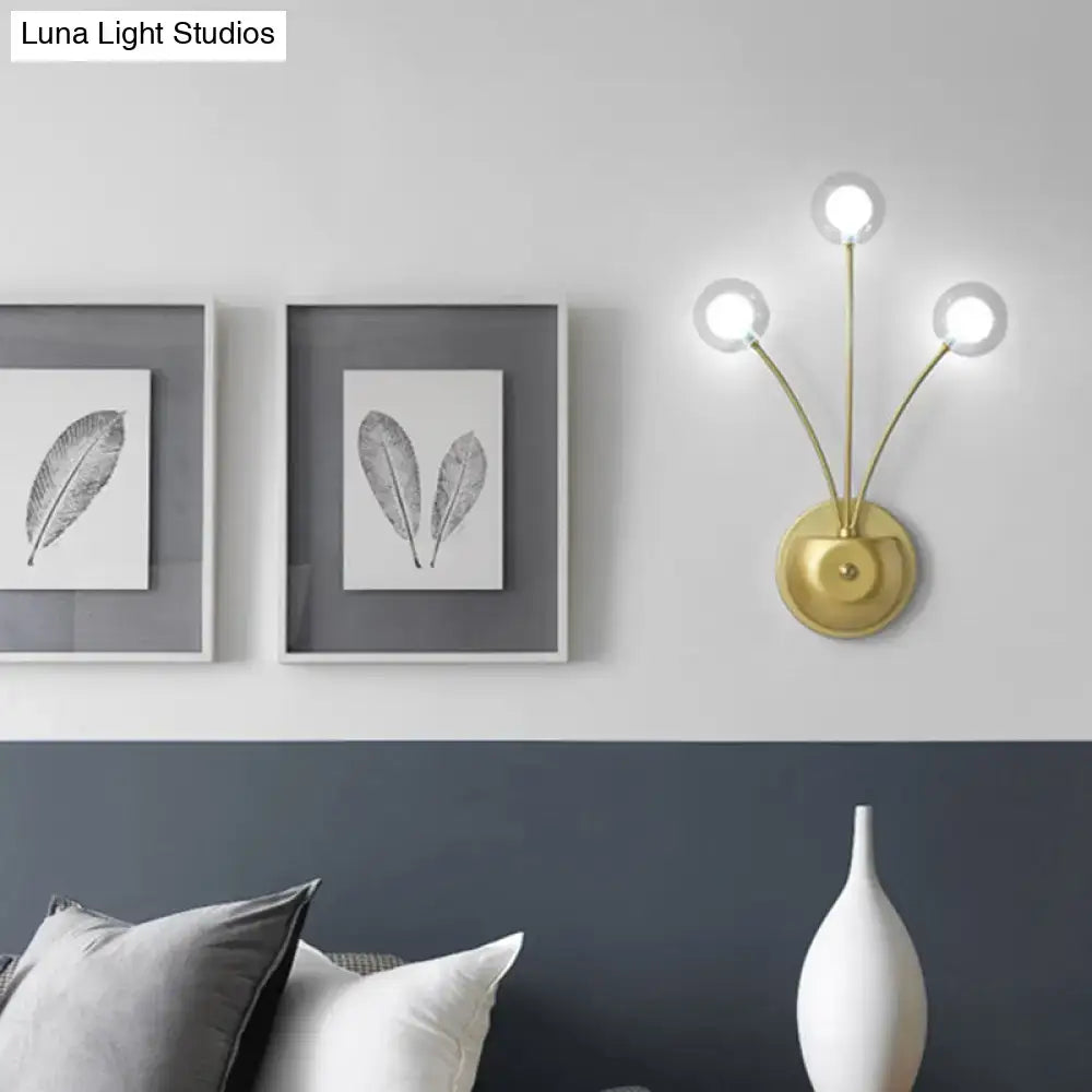 Gold-toned cast iron wall sconce with three curved arms and clear globes, modern inches fixture for living room lighting