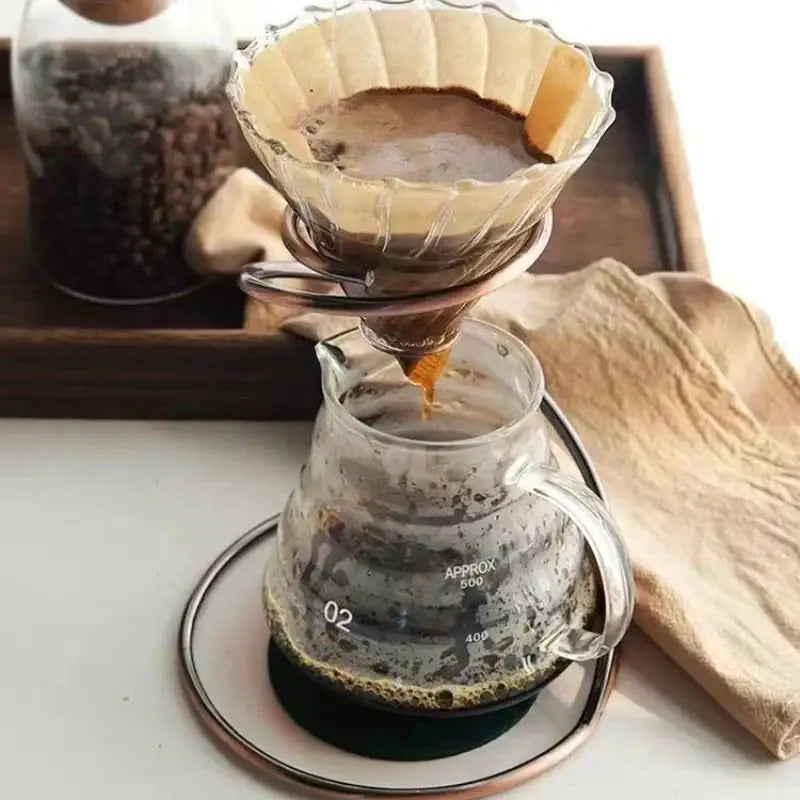 Clear glass pour-over coffee dripper with fluted paper filter and dark grounds in modern black ceramic coffee barista set decorbites coffee