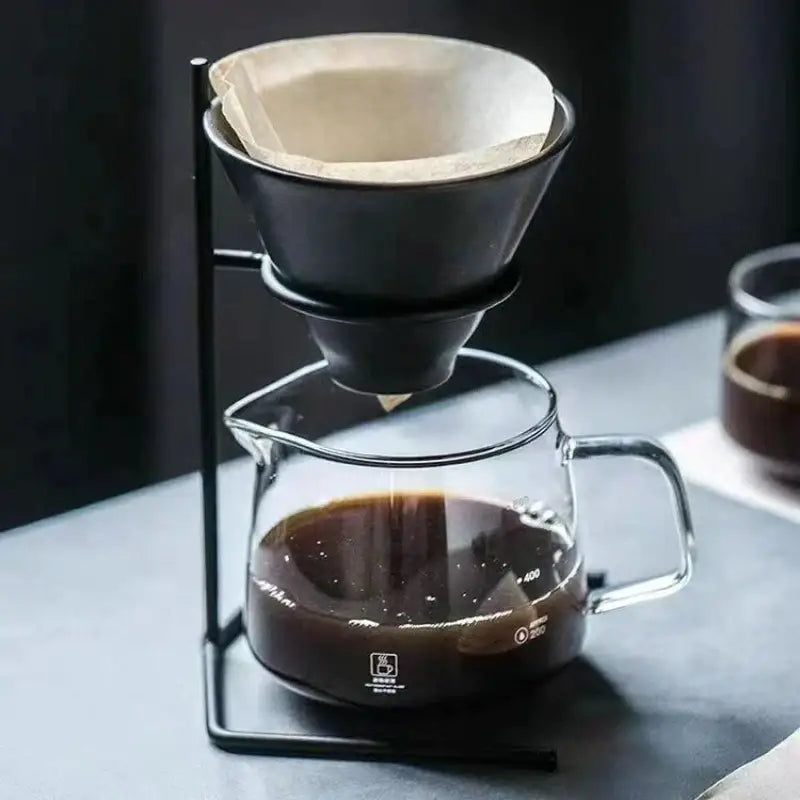 Modern black ceramic coffee barista set pour over dripper with paper filter resting on glass carafe by decorbites coffee