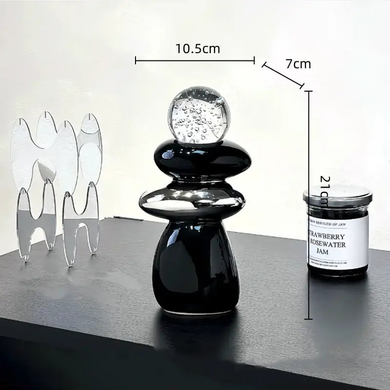 Modern black ceramic decorative crystal ball statue with stacked smooth forms and bubble-filled glass sphere for living room decor