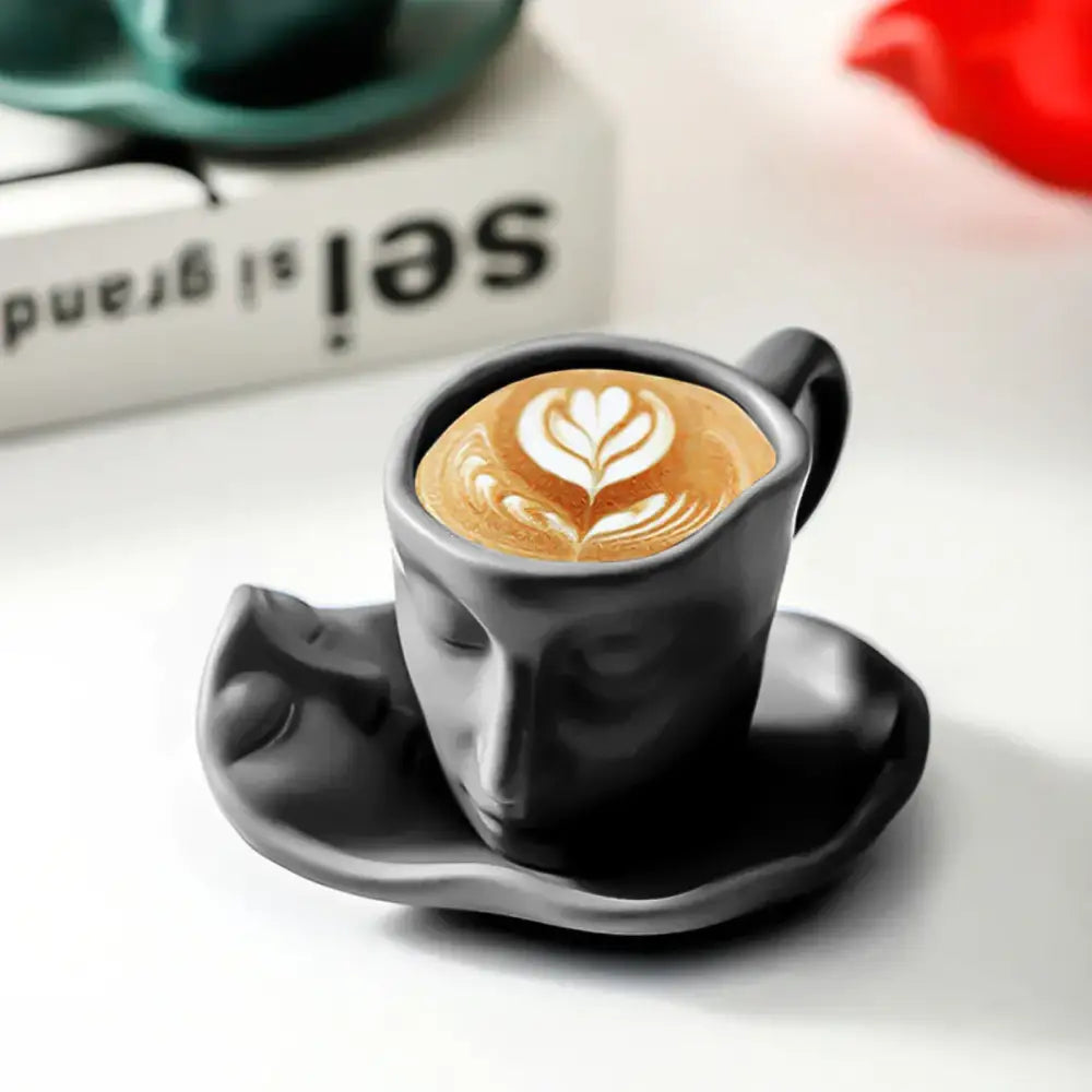 Modern black ceramic tea cup set featuring a black ceramic coffee cup with face design and white leaf latte art