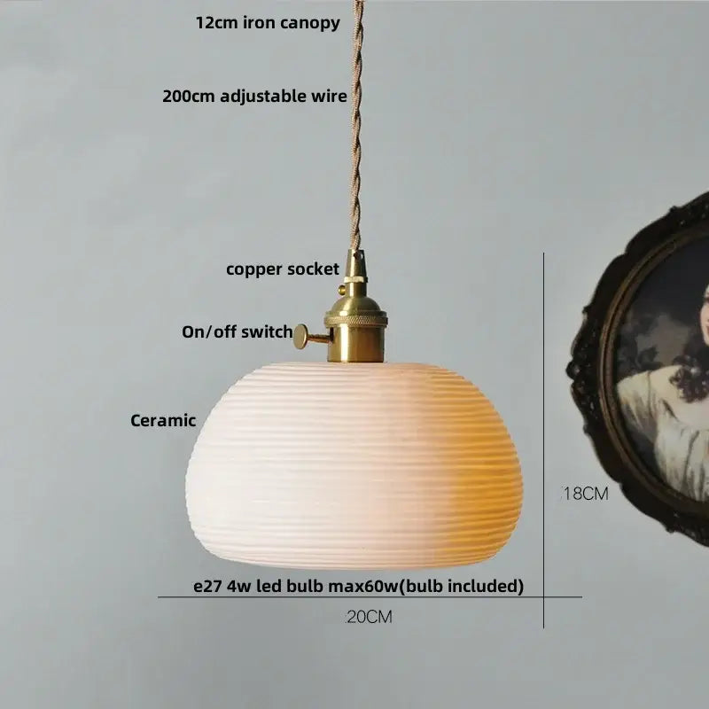 A warm-toned modern black ceramic led pendant light with brass detail featuring a ribbed gradient finish from white to amber