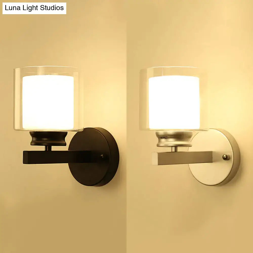 Modern black and chrome wall mounted clear glass sconce with cylindrical shade for bedroom lighting