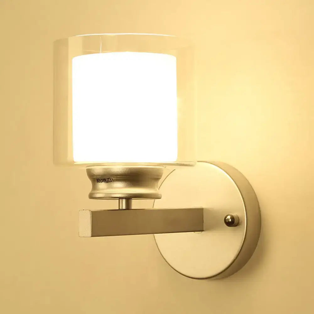 Modern black and chrome wall mounted clear glass sconce with cylindrical shade for bedroom lighting