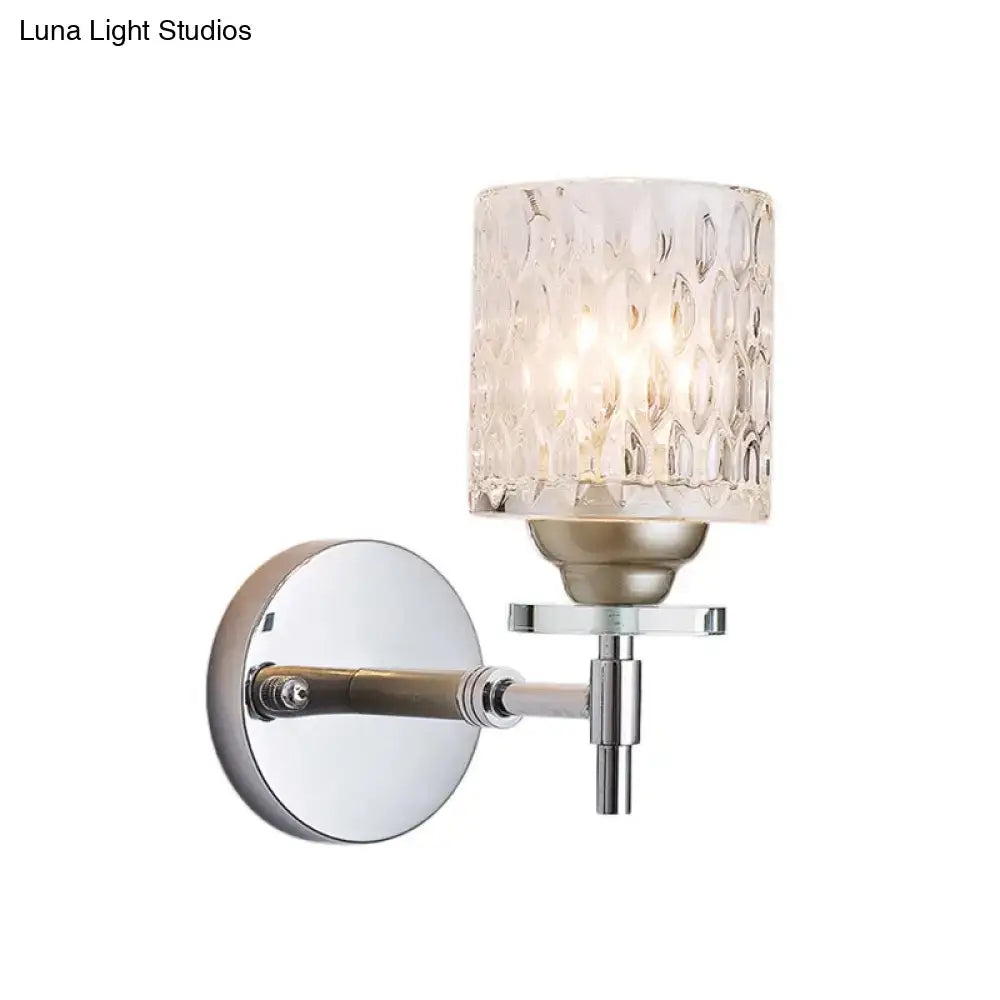 Modern black chrome wall sconce with dimpled glass cylinder shade and polished metal accents for bedroom lighting