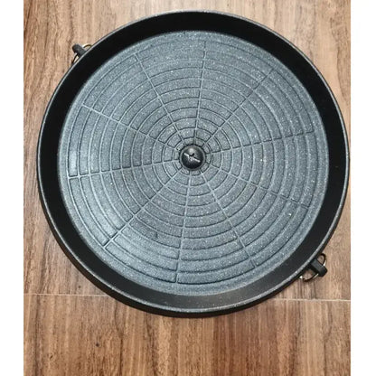 Modern black circular korean grill pan with textured concentric grid pattern and two side handles for kitchen bbq use