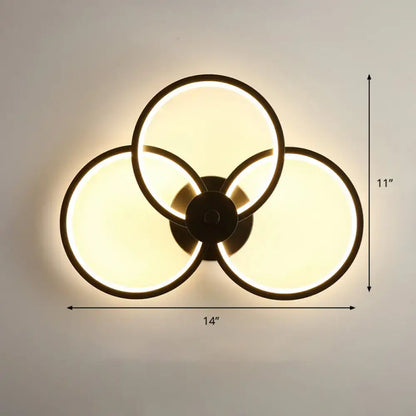 Modern black circular led light fixture wall sconce with three overlapping illuminated rings and remote control function