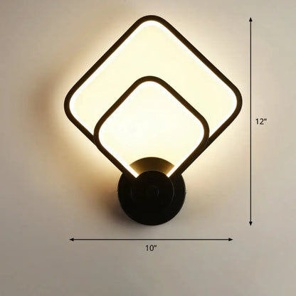 Modern black circular led light fixture wall sconce with overlapping square panels emitting warm glow and remote control feature