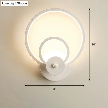 Modern black circular led light fixture with remote control and white concentric ring wall sconce for ambient bedroom lighting