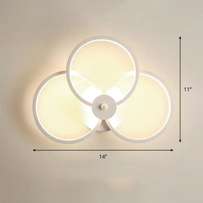 Modern black circular led light fixture bedroom wall sconce with three overlapping illuminated white rings and remote control