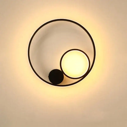 Modern black circular led wall lamp with warm glowing light and minimalist geometric design for bedroom use