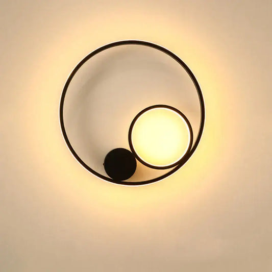 Modern black circular led wall lamp with warm glowing light and minimalist geometric design for bedroom use